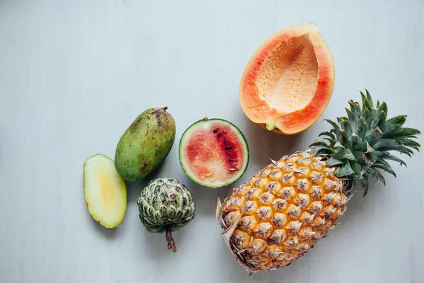 De verscheidenheid van exotische vruchten op witte tafel. Vers fruit op tabblad gesneden — Stockfoto