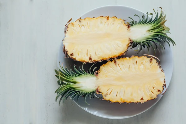 Skivad färsk ananas på tallriken på bordet. Vit ba — Stockfoto