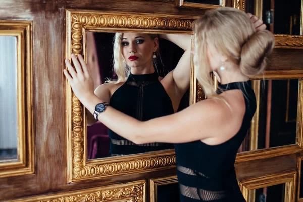 Сексуальная женщина в маленьком черном платье, позирующая возле зеркал. мода — стоковое фото