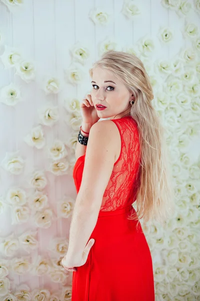 Linda menina loira com lábios vermelhos em vestido vermelho posando em flor — Fotografia de Stock