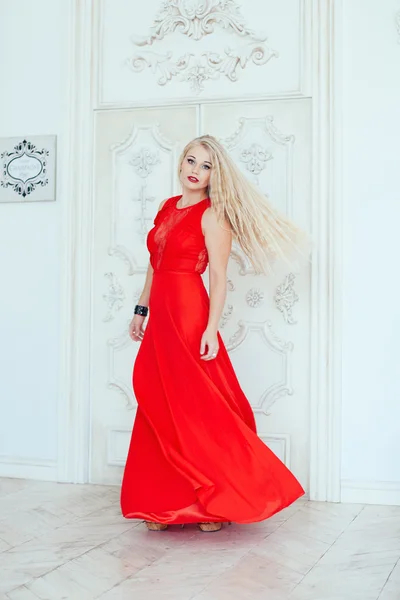 Giovane donna di bellezza in abito rosso svolazzante. Contesto interno — Foto Stock
