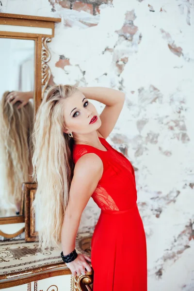 Портрет молодой красивой блондинки с красными губами в красном платье — стоковое фото