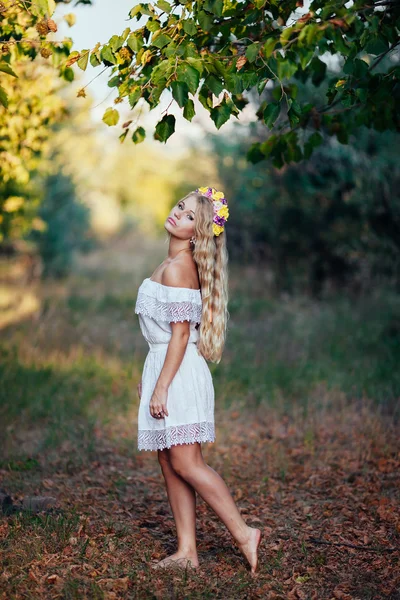 Full-length Retrato de menina loira vestindo vestido branco com coroa de flores — Fotografia de Stock
