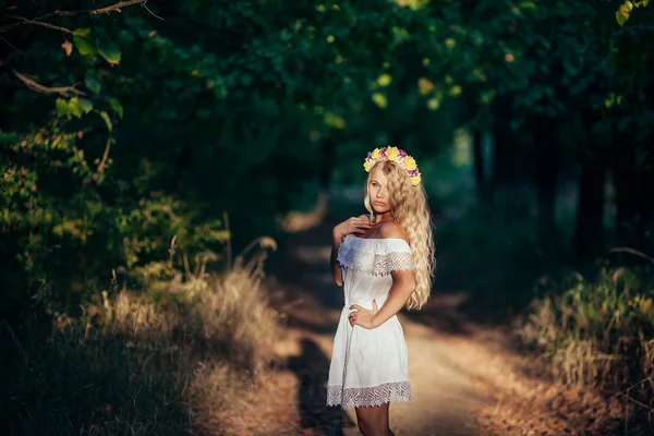 Portret van blond meisje dragen witte jurk met bloem krans — Stockfoto