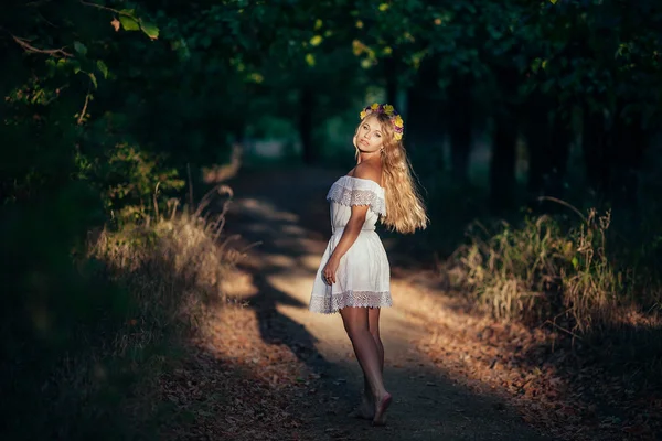 Портрет блондинки в белом платье с цветочным венком — стоковое фото