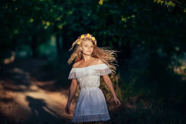 Portrét blond dívka, která nosí bílé šaty s květinový věnec — Stock fotografie