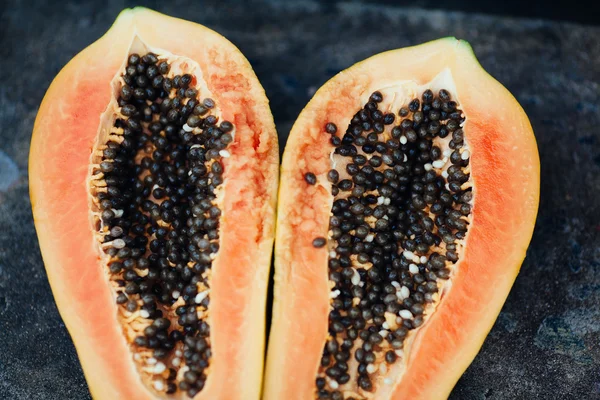 sliced papaya fruit on black background