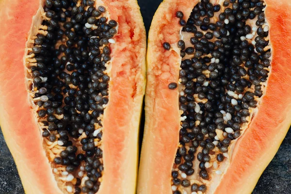 sliced papaya fruit on black background