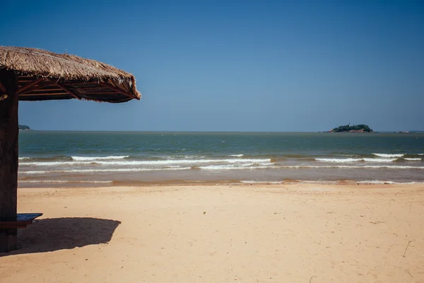 Пляжный зонтик на песке рядом с тропической лагуной. Солнечные зонтики — стоковое фото