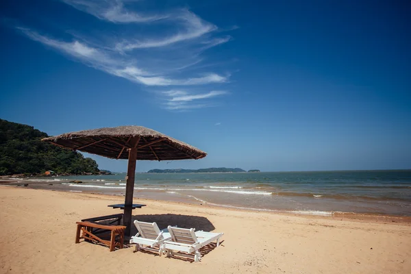 Песочный пляж с шезлонгами с солнечными лучами и облачным блу — стоковое фото