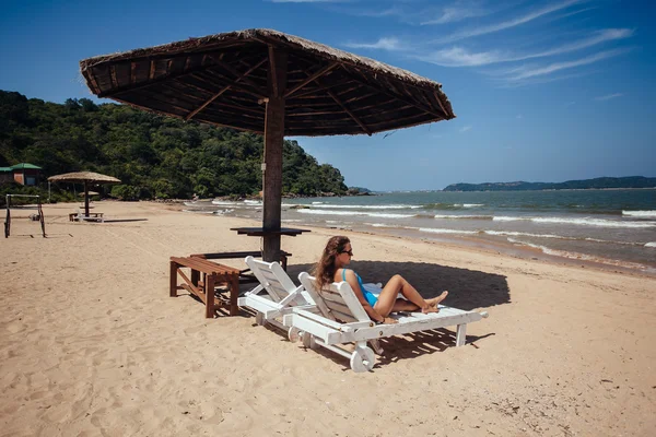 Mujer en una playa tropical en la tumbona bajo el sol umbrella.woman —  Fotos de Stock