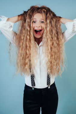 Mavi arka plan üzerinde uzun sarı saçlı kız gülümseyerek