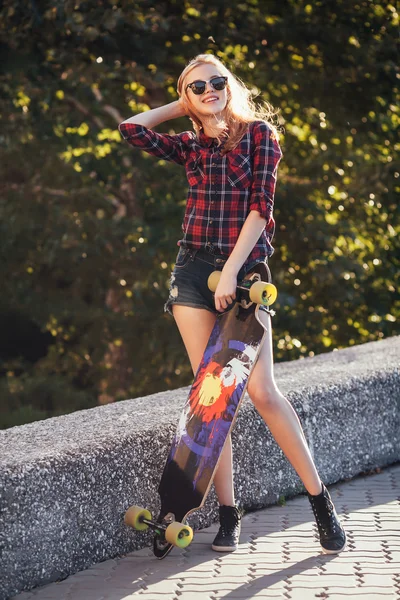Sportovní móda dívka pózuje v létě s skateboard — Stock fotografie