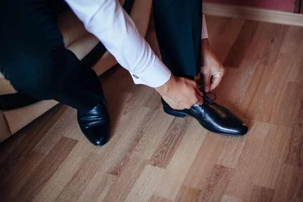 El hombre se pone zapatos. Enfoque en los cordones — Foto de Stock