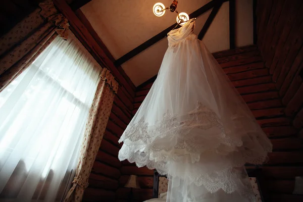 Abito da sposa appeso sulla lucentezza in camera d'albergo — Foto Stock