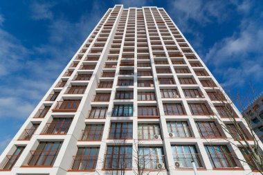 Aşağıdan yukarıya çok katlı bir binanın ön cephesi