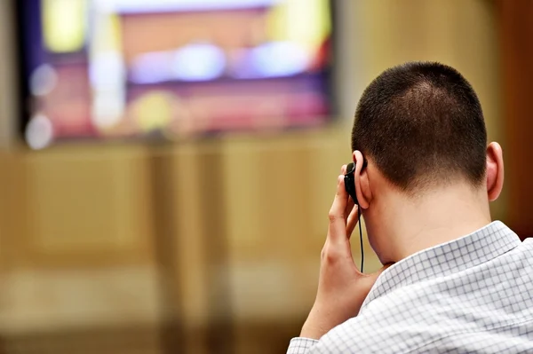 Uomo che utilizza cuffie di traduzione durante la presentazione video — Foto Stock