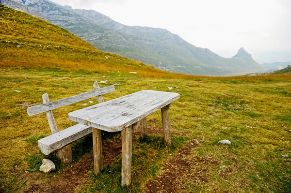 Prázdné dřevěné lavice a stůl na hoře — Stock fotografie