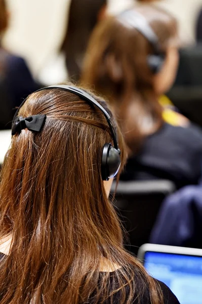 Ανθρώπους των επιχειρήσεων χρησιμοποιεί ακουστικά για τη μετάφραση — Φωτογραφία Αρχείου