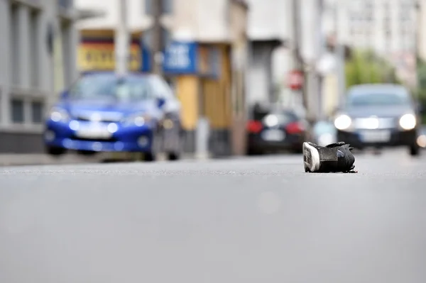 Shoe on the street with cars in background after accident — Stock Photo, Image