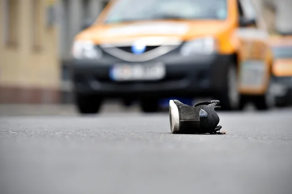 Shoe on the street with cars in background after accident — Stock Photo, Image