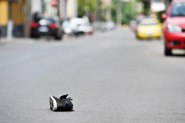 Schuh auf der Straße mit Autos im Hintergrund nach Unfall — Stockfoto