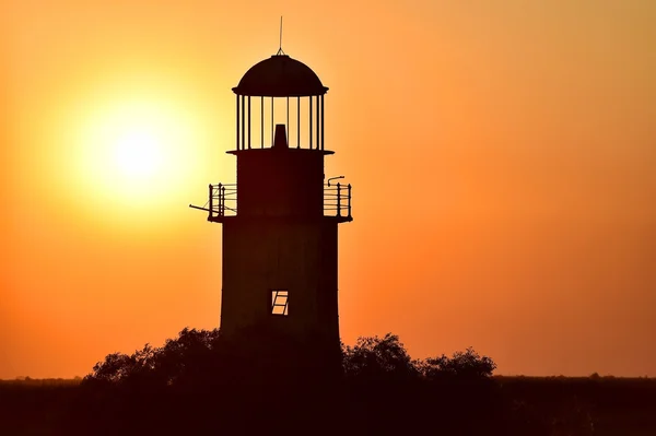 Abandoned lighthouse at sunset on a river — Stock Photo, Image