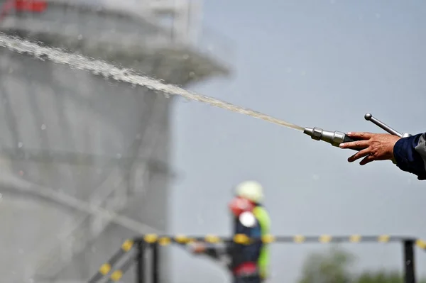 Bombeiro segurando mangueira de água de alta pressão — Fotografia de Stock