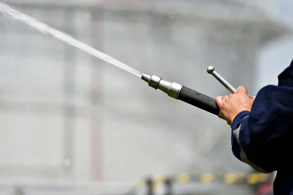 Feuerwehrmann mit Hochdruck-Wasserschlauch — Stockfoto