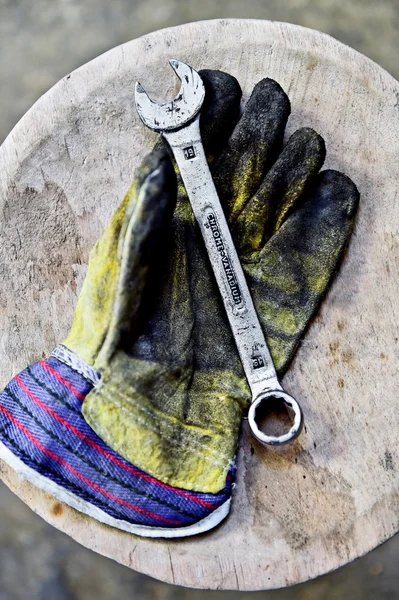 Guante de trabajador sosteniendo llave de la llave de aceite — Foto de Stock