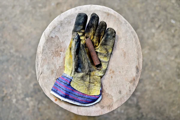 Guante de trabajador que sostiene la primavera oxidada —  Fotos de Stock