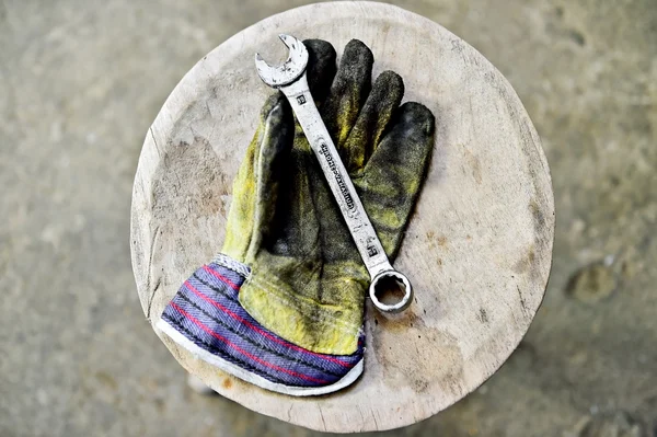 Guante de trabajador sosteniendo llave de la llave de aceite — Foto de Stock