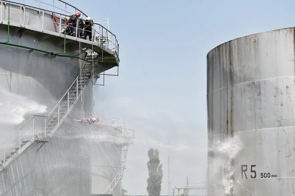 Pemadam kebakaran jet air pada tangki penyimpanan besar — Stok Foto