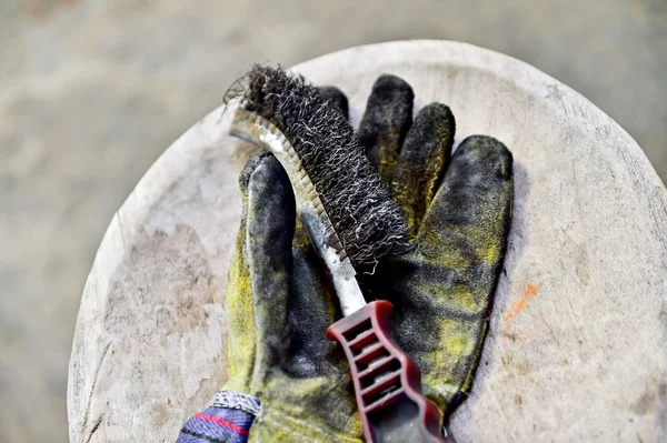 Guante de trabajador sosteniendo cepillo de alambre — Foto de Stock