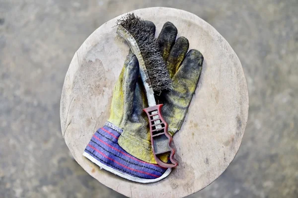 Worker's glove holding wire brush — Stock Photo, Image