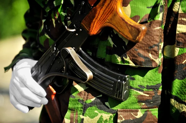 Soldier hand on AKM rifle — Stock Photo, Image