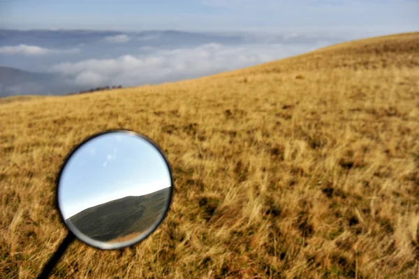 Montanhas são vistas em um espelho de moto — Fotografia de Stock