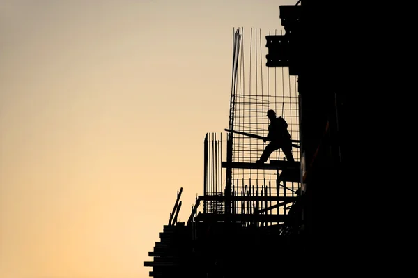 Silueta de trabajador de la construcción al atardecer —  Fotos de Stock