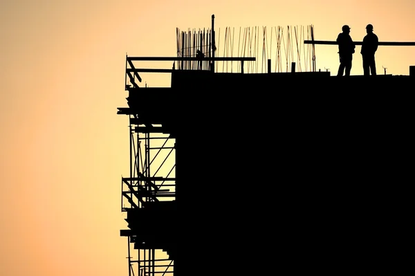 Silhouettes de travailleurs de la construction au coucher du soleil — Photo