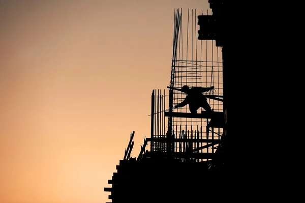 Silueta de trabajador de la construcción al atardecer — Foto de Stock