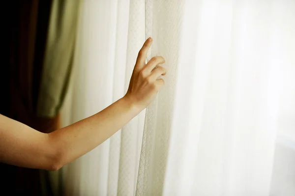 Hand zieht einen Fenstervorhang — Stockfoto