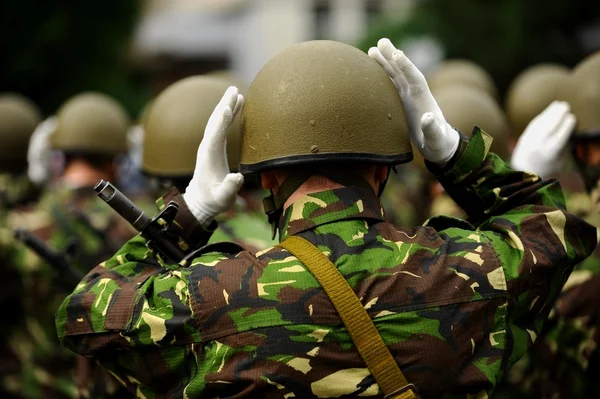 Солдаты в камуфляжной форме раскладывают шлемы — стоковое фото