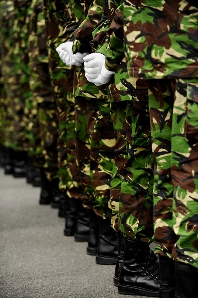 Солдаты в камуфляжной форме с руками за спиной — стоковое фото