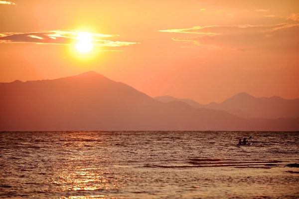 Ludzie spływy kajakowe po jeziorze Szkodra na zachodzie słońca — Zdjęcie stockowe