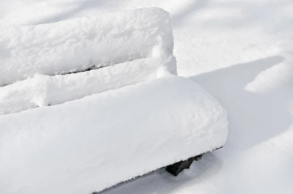 Lavička v parku zcela pokryty sněhem — Stock fotografie