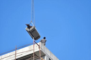 Bir inşaat vinç rehberlik inşaat işçisi