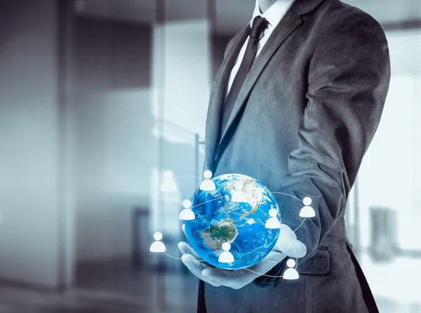 Бизнесмен держит глобус в руках. Концепция управления персоналом во всем мире — стоковое фото