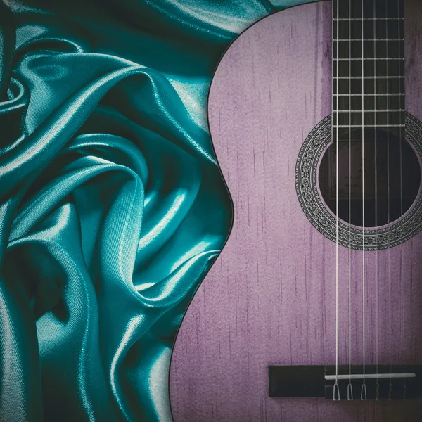 Teil einer blauen Akustikgitarre auf Seidengrund. — Stockfoto