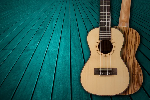 Parte de una guitarra acústica azul sobre un fondo de madera . — Foto de Stock