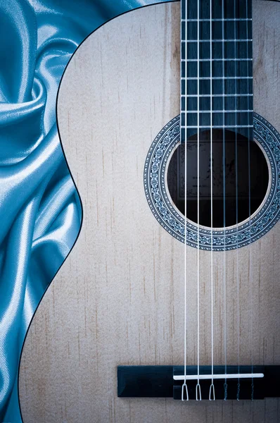 Parte de una guitarra acústica azul sobre fondo de seda . — Foto de Stock